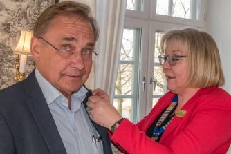 Marius Bundgaard Lauridsen får sin 25 års nål af præsident Birgitte Feldborg.